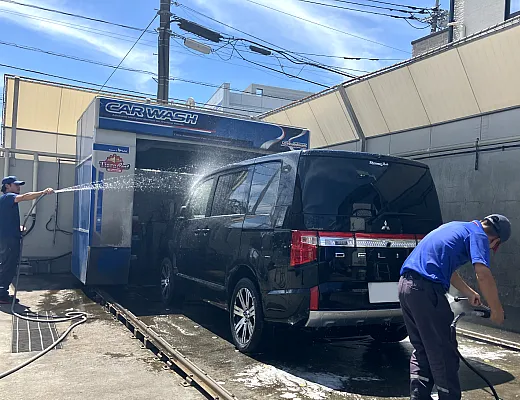 スタッフが手洗い洗車で洗い流しをしている写真